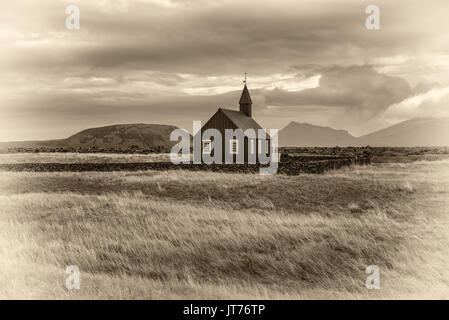 Décor d'église en bois noir de Budir en Islande avec les pâturages et les montagnes en arrière-plan. Vintage noir et blanc traité. Banque D'Images