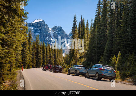 MORAINE LAKE, ALBERTA, CANADA - LE 27 JUIN 2017 : parc de voitures le long de la route pour le lac Moraine, dans le parc national Banff, Alberta, Canada, avec des pe Banque D'Images