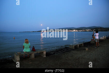 La pleine lune avec une éclipse partielle, s'élève au-dessus d'Oropos dans la baie d'Eubée, à 30 milles à l'est d'Athènes, Grèce. Lundi 07 Août 2017 Banque D'Images