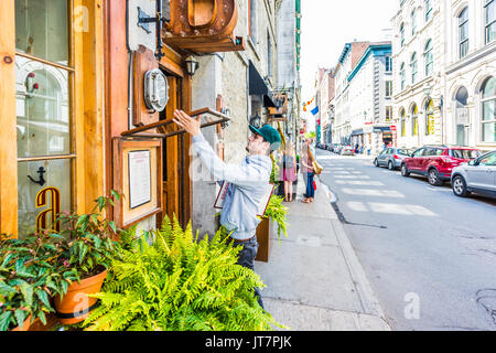 Montréal, Canada - le 28 mai 2017 : Man changing Restaurant menu à l'extérieur par trottoir en matinée par street pendant la journée à l'extérieur entrée dans la région du Québec : Banque D'Images