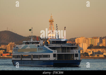 Rio de Janeiro, Brésil, le 7 août 2017 : Rio de Janeiro est ensoleillé et chaud après-midi en hiver. Dans cette image, les bateaux qui font la traversée entre Rio de Janeiro et Niterói. Dans l'arrière-plan, la plate-forme pétrolière en 2009 dans l'ancre pendant le coucher du soleil vu de la baie de Guanabara, le centre-ville de Rio. Banque D'Images