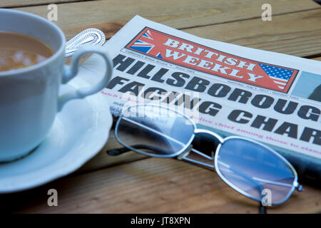 Une copie de l'hebdomadaire britannique sur une table en Californie. Un journal de réseau des expatriés anglais en Amérique latine avec une tasse de thé et d'une paire de lunettes de lecture Banque D'Images