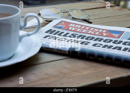 Une copie de l'hebdomadaire britannique sur une table en Californie. Un journal de réseau des expatriés anglais en Amérique latine avec une tasse de thé et d'une paire de lunettes de lecture Banque D'Images