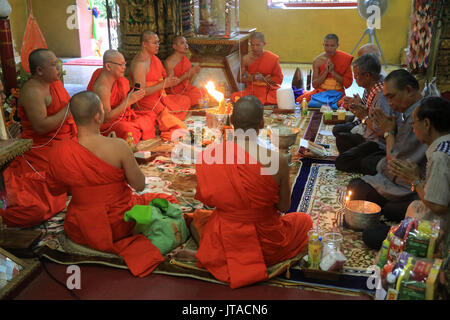 Les moines bouddhistes priant, Sai Sin, le fil de coton symbolisant le lien sacré, Simuong Wat (Wat Si Muang), Vientiane, Laos, Indochine, Asie du sud-est Banque D'Images