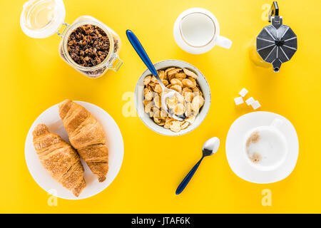 Vue de dessus du délicieux petit-déjeuner avec des céréales, croissants et café sur jaune Banque D'Images