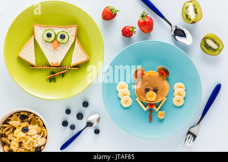 Mise à plat avec un style de façon créative le petit déjeuner des enfants aux fruits rouges et kiwi Banque D'Images