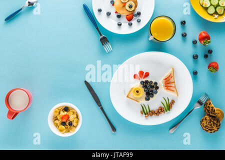 Mise à plat avec un style de façon créative le petit déjeuner des enfants sur les plaques Banque D'Images