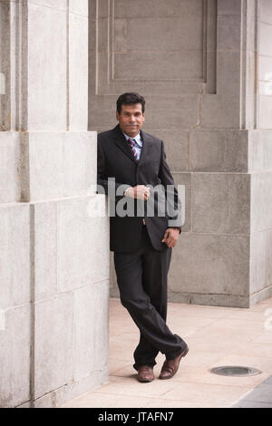 L'homme d'affaires indien dans la ville d'Asie. Portrait d'un Asian businessman smiling & regardant la caméra. Banque D'Images