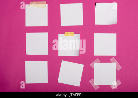 Close-up view of blank white notes adhésives isolé sur pink Banque D'Images