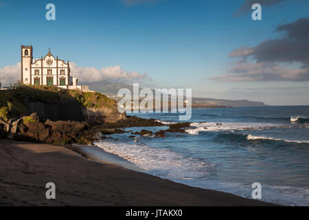 Côte de l'île de São Miguel, ville Sao Roque. Église sur une colline. Plage de l'avant-plan. Ciel nuageux. Açores, Portugal. Banque D'Images