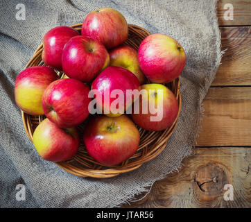 La récolte de pommes fraîches. Thème de la nature avec des raisins rouges et panier sur fond de bois. Concept fruits de la nature. Banque D'Images