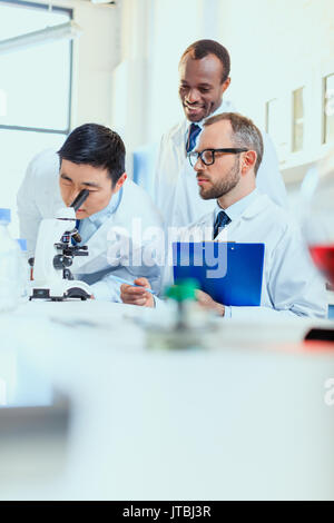 Les jeunes médecins en uniforme travaillant au laboratoire d'essai, les techniciens de laboratoire Banque D'Images