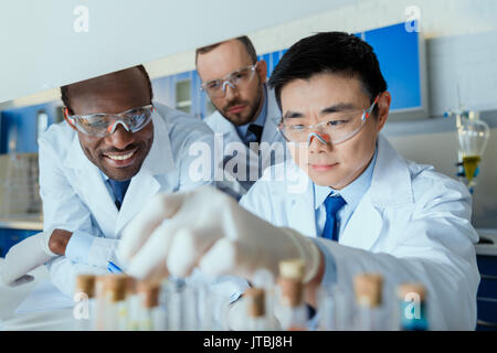 Groupe multiethnique de scientifiques en travaillant ensemble dans des lunettes de laboratoire chimique Banque D'Images