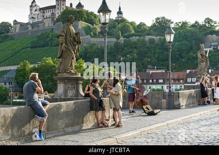 Un passe-temps populaire dans la ville allemande de Würzburg est rencontrer des amis pour un verre (ou deux !) de vin de Franconie sur le vieux pont. Banque D'Images