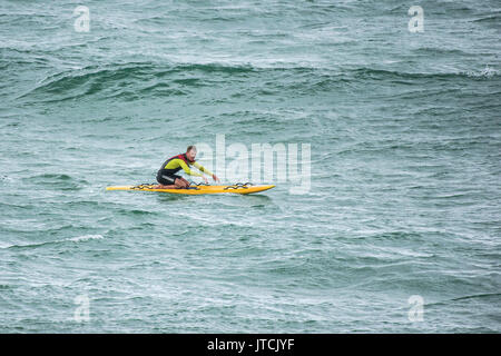 Un sauveteur RNLI sur son canot de sauvetage planche de surf. Banque D'Images