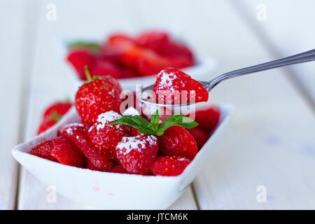 Cuillerée de sucre fraise mûre frais enrobé d'un bol de fruit Banque D'Images