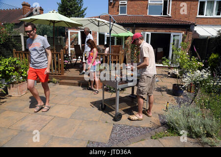 Family Having A Barbecue dans jardin pendant l'été Birmingham West Midlands England Banque D'Images