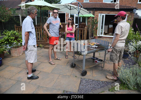 Family Having A Barbecue dans jardin pendant l'été Birmingham West Midlands England Banque D'Images