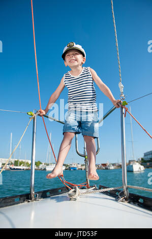 Heureux petit garçon portant le capitaine cap sur luxury yacht blanc en journée d'été Banque D'Images