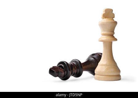 Deux roi en bois pièces des échecs sur blanc, un en bois clair debout et le sombre roi couché sur le côté avec copyspace Banque D'Images