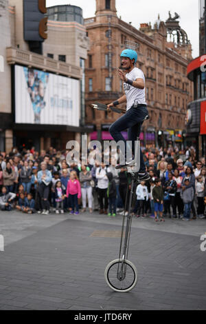 Un juggling unicyclist effectuer pour les foules à Leicester Square à Londres. À partir d'une série de photos d'artistes de rue, à Londres, au Royaume-Uni. Date de la photo : T Banque D'Images