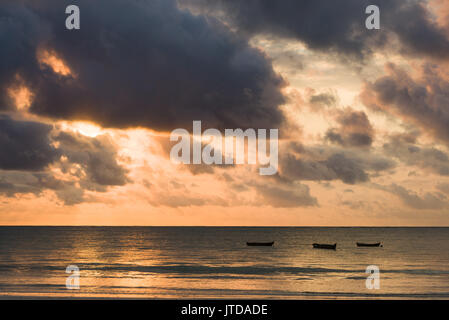 La silhouette du boutre tôt le matin, la lumière du soleil à travers les nuages de rupture de l'océan Indien, Diani, Kenya
