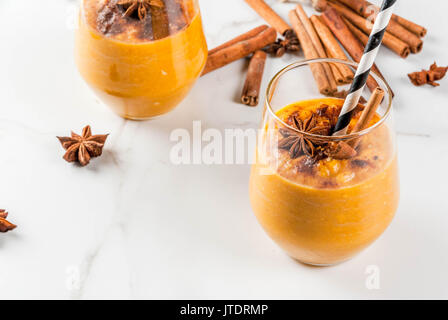Des plats traditionnels de l'automne, épicé à la citrouille avec de la cannelle, l'anis smoothie et le gruau. Dans les verres, les portions sur table de marbre blanc. Copy space Banque D'Images