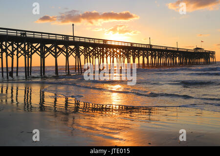 Lever du soleil à une côte de l'Atlantique, de la Caroline du Sud Myrtle Beach, États-Unis d'Amérique. Paysage avec le reflet du soleil dans l'eau peu profonde sur l'avant plan et une Banque D'Images