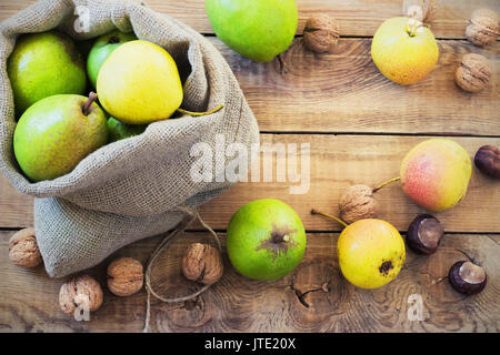 Composition d'automne de fruits, de noix et d'épices - Poires, Noix, feuilles d'érable sur un fond de bois toning Banque D'Images
