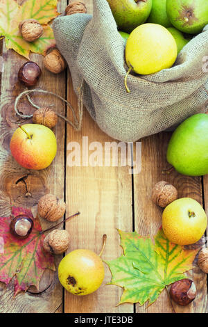 Composition d'automne de fruits, de noix et d'épices - Poires, Noix, feuilles d'érable sur un fond de bois toning Banque D'Images