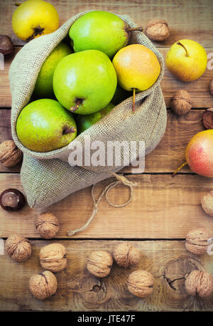 Composition d'automne de fruits, de noix et d'épices - Poires, Noix, feuilles d'érable sur un fond de bois toning Banque D'Images
