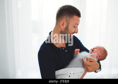 Père avec cute pleurer bébé nouveau-né Banque D'Images