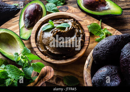 Mousse au chocolat à l'avocat de bol en bois d'olive. Bacground en bois Banque D'Images