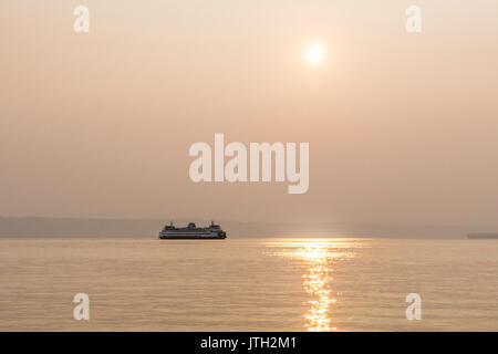 Puget Sound, Edmonds, Washington, USA. Le 08 août, 2017 au sud de la dérive fumée. Les incendies de forêt en Colombie-Britannique donne à Edmonds, Washington, États-Unis d'un beau coucher de soleil brumeux sur Puget Sound, obscurcissant la péninsule Olympique, en tant que port ferry glisse dans le 8 août 2017 Crédit : Dorothy Alexander/Alamy Live News Banque D'Images