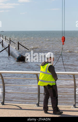 Un nouveau tuyau d'évacuation des eaux d'inondation a été transporté par bateau de Norvège à la côte de l'Irlande et est maintenant installé à Anchorsholme Beach, Blackpool, Lancashire. Août 2017. Ce nouveau tuyau d'évacuation submergé prolongé déchargera l'excès d'eaux pluviales préfiltrées vers la mer et fait partie des améliorations apportées au système de gestion de l'eau de la côte de Fylde. Rempli d'air pour le maintenir à flot, le tuyau de 20 000 tonnes a quitté l'Irlande samedi après-midi et a été tiré à travers la mer d'Irlande avec une escorte de 4 navires. Banque D'Images