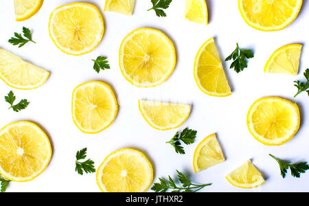 Les tranches de citron et feuilles de persil sur fond blanc Banque D'Images