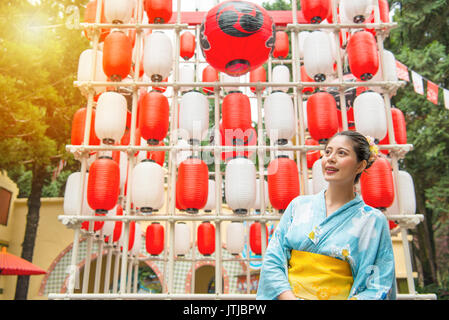 Traveler smiling woman standing in front of lantern festival japonais décoration profitez de groupe et le port de kimonos traditionnels japonais au cours d'un voyage. Banque D'Images