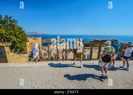 Les touristes profiter de la belle vue sur la mer Méditerranée depuis les anciennes ruines de l'Acropole de Lindos sur l'île de Rhodes, Grèce Banque D'Images