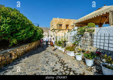 Une petite pierre street à Lindos sur l'île de Rhodes en Grèce par une chaude journée d'été Banque D'Images