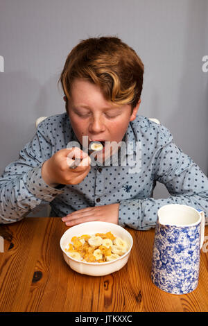 Boy eating corn flakes pour le petit déjeuner Banque D'Images