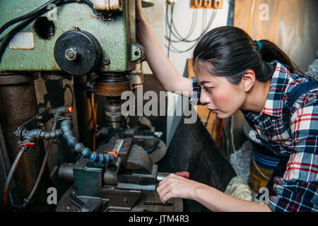 Usine de composants attrayant femmes régler des machines industrielles pour le forage travaillant en usine Ministère de la fraiseuse. Banque D'Images