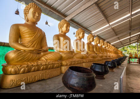 Statues de Bouddha en bronze avec des bols pour dons à l'Phuket Big Buddha Park, Chalong, Thaïlande Banque D'Images