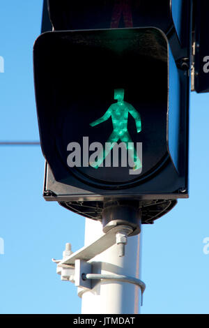 Panneau de sécurité : homme vert traversant une route. Banque D'Images