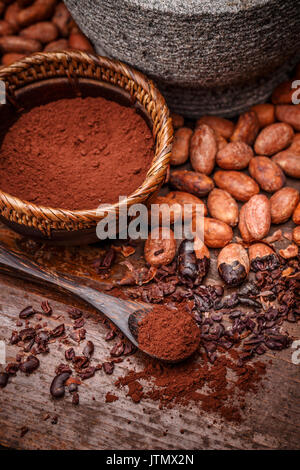 Les fèves de cacao et poudre de cacao sur planche de bois Banque D'Images