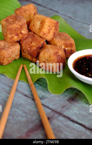 La nourriture végétarienne frugale de la cuisine vietnamienne, tofu frit avec puissance d'épices croustillant, couvrir avec la farine, des aliments sur l'arrière-plan de la feuille verte, le soja sau Banque D'Images