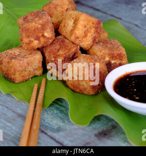 La nourriture végétarienne frugale de la cuisine vietnamienne, tofu frit avec puissance d'épices croustillant, couvrir avec la farine, des aliments sur l'arrière-plan de la feuille verte, le soja sau Banque D'Images