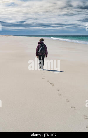 Seule femme marchant sur la plage ouest Berneray Banque D'Images