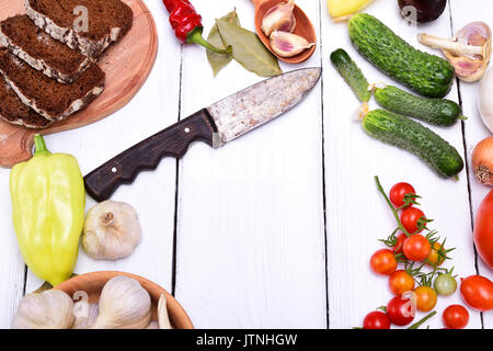 Légumes frais, tomates, concombre et le poivre sur une table en bois blanc, l'espace vide au milieu Banque D'Images