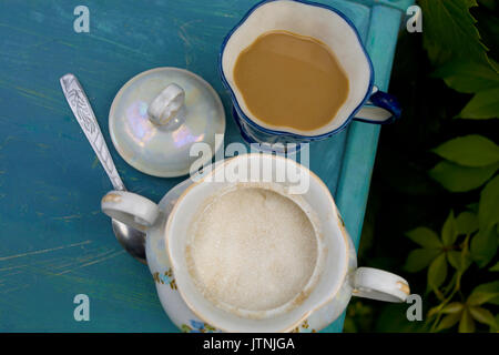 Photo recadrée de frais généraux d'un sucrier avec thé ou café tasse sur le dessus de la vieille table en bois. Tourné en extérieur Banque D'Images