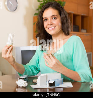 Souriante jeune femme aux cheveux long avec ampoules brassée de Banque D'Images